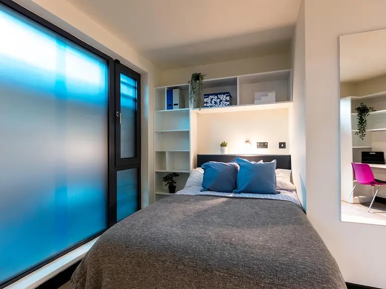Bed with blue pillows and shelves Bedroom at Brewers Close in Dublin Student Accommodation