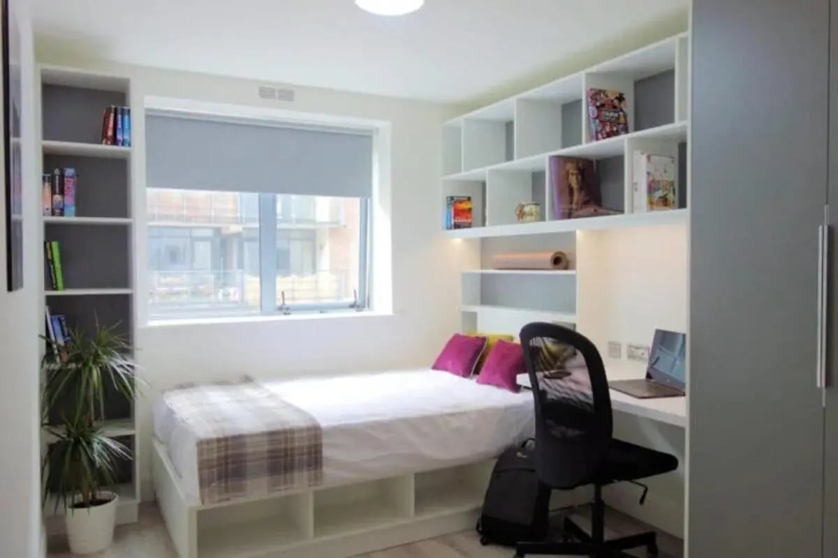 Bed desk bookshelves laptop and plant bedroom at Mayor Square in Dublin Student Accommodation