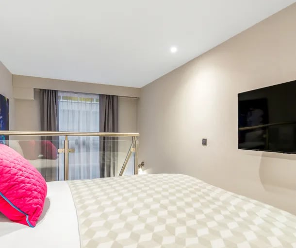 Bed with pink pillow and television Bedroom at Gravity in Lincoln Student Accommodation