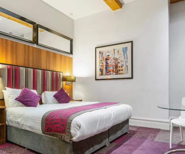 Bed with purple pillows and art bedroom at IconInc Manchester City in Manchester Student Accommodation