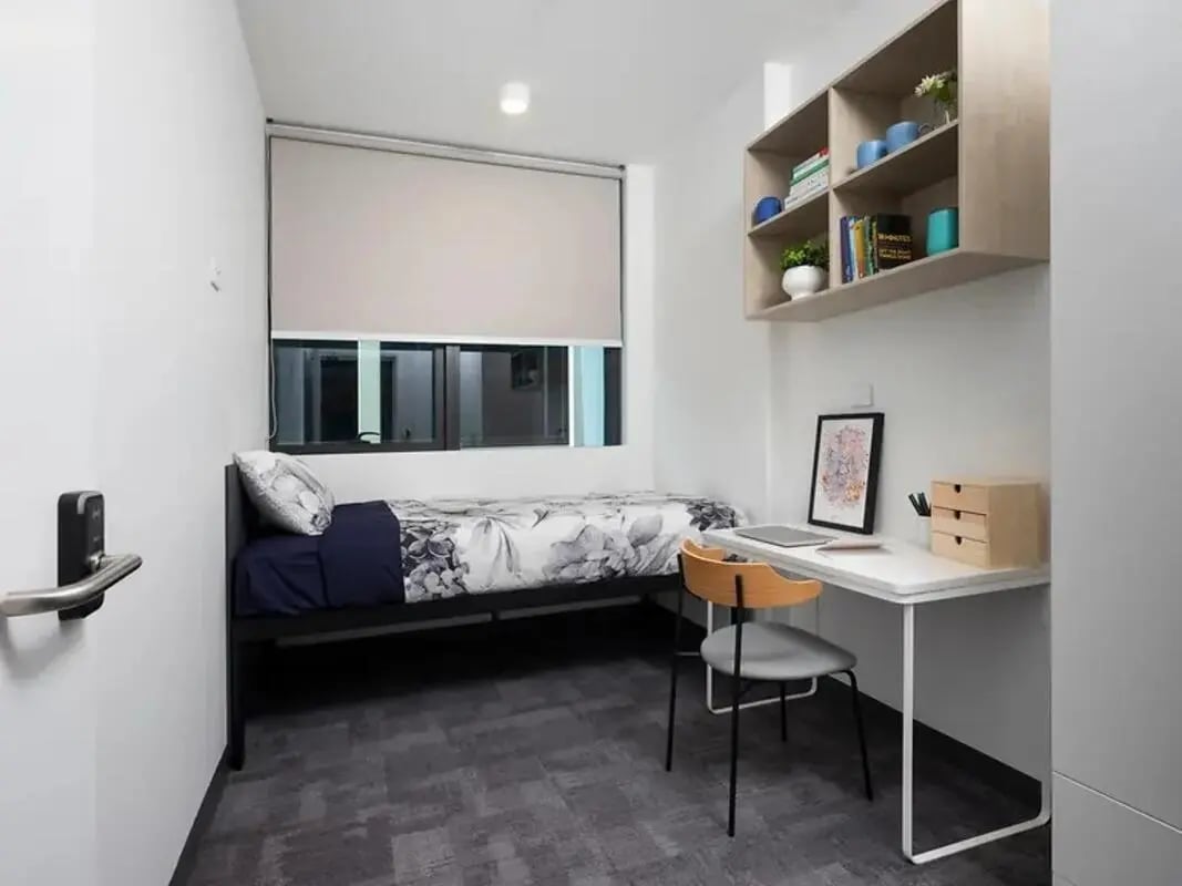 Bed desk shelf and chair bedroom at Yugo Adelaide City in Adelaide Student Accommodation