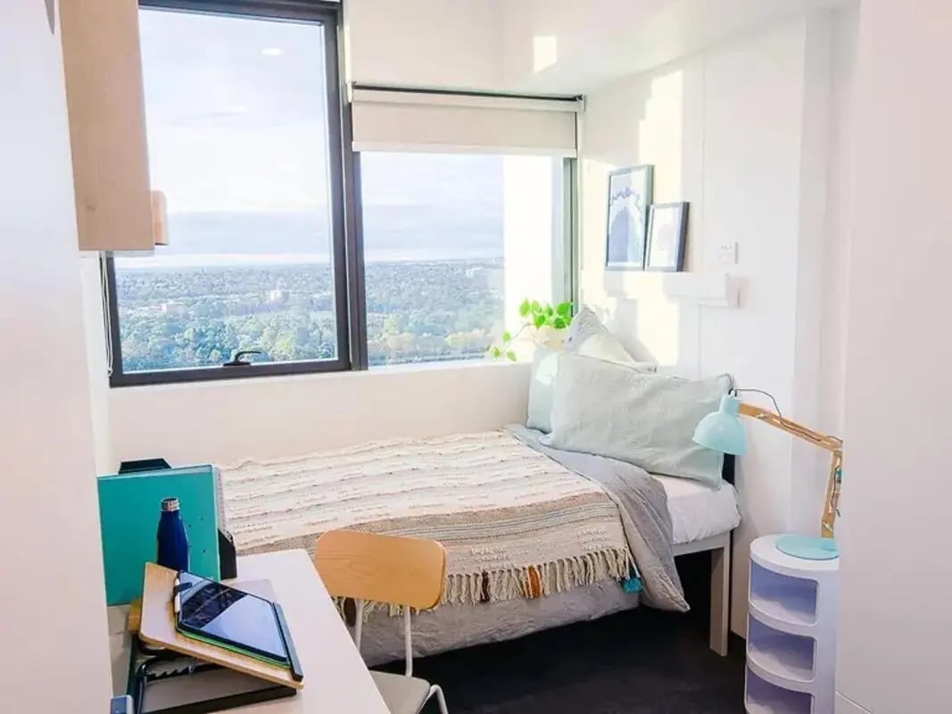 Bed desk lamp and city view bedroom at Yugo Adelaide City in Adelaide Student Accommodation