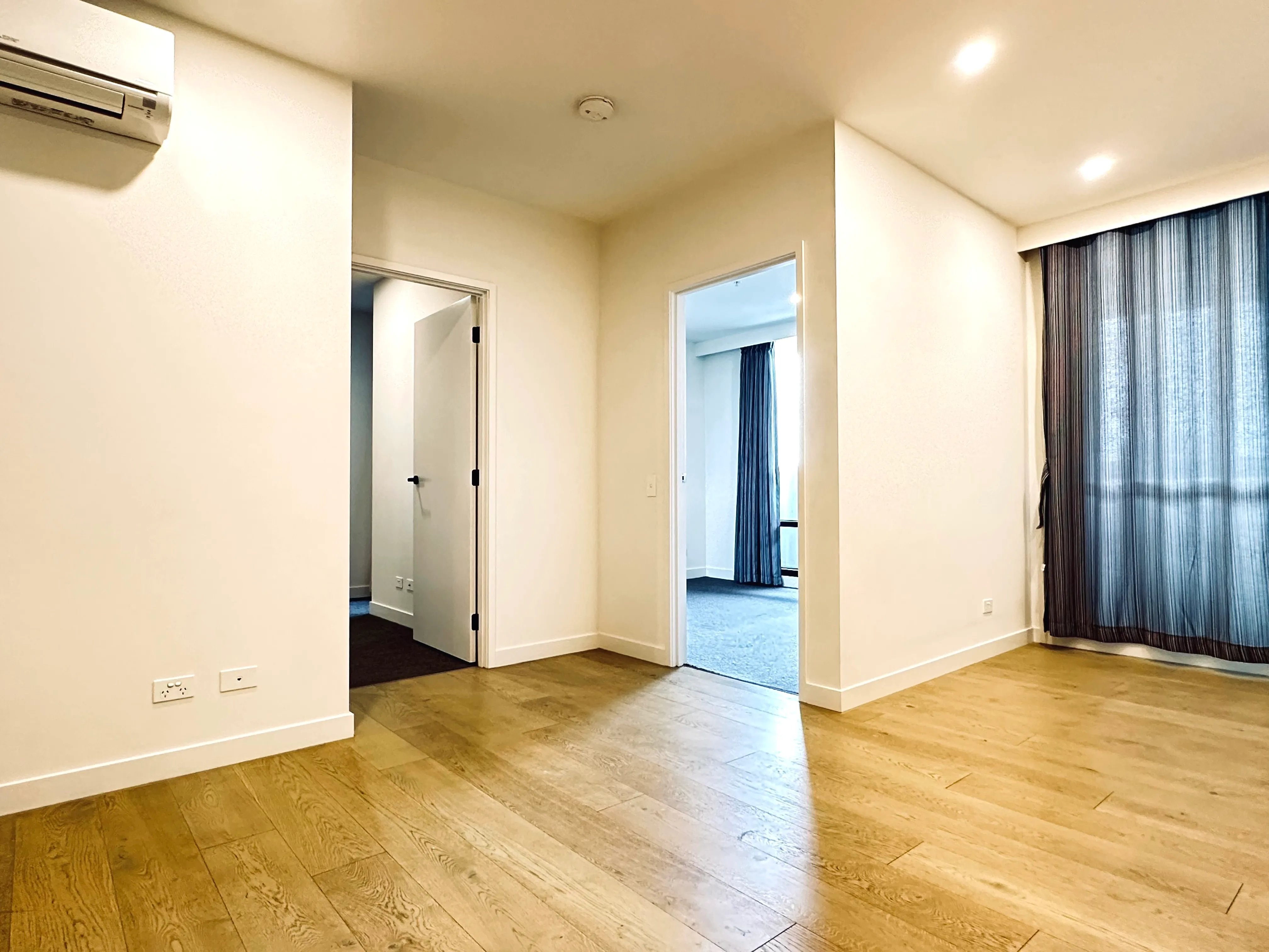 Empty apartment with wooden floor and air conditioning Living room at BELONG Clayton Melbourne in Melbourne Student Accommodation