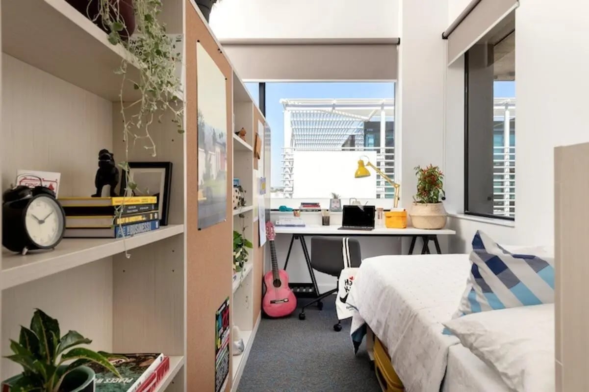 Bed desk guitar bookshelf alarm clock bedroom at Campus Perth in Perth Student Accommodation