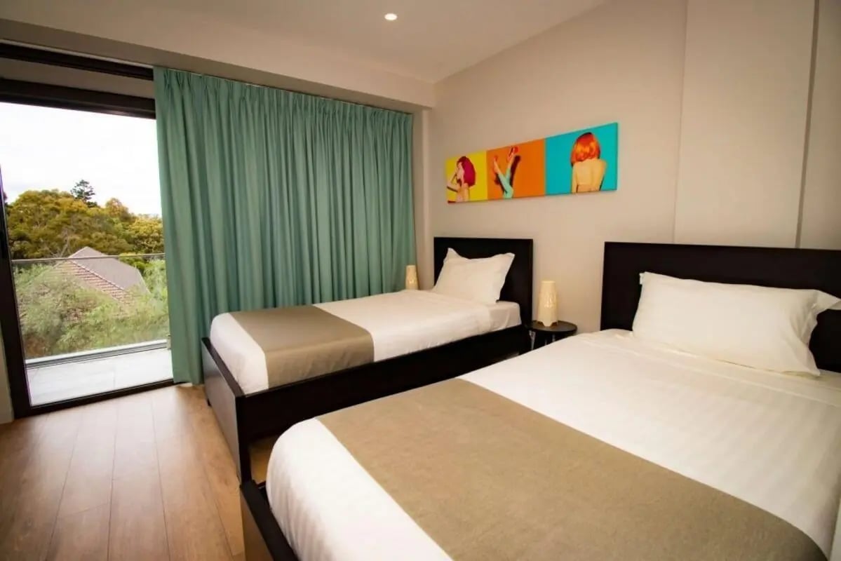 Two beds with bedside lamps artwork bedroom at Sydney Student Living Top Ryde in Sydney Student Accommodation