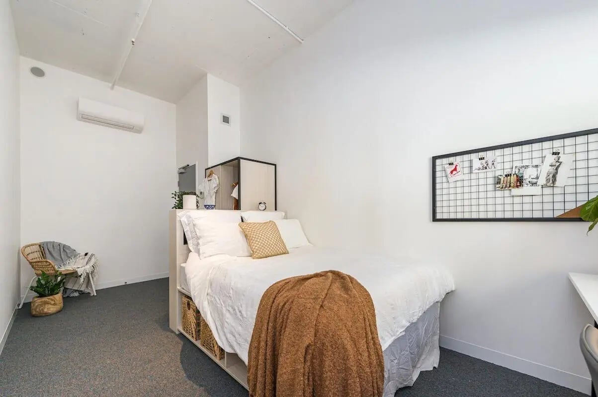 White bed chair and plant bedroom at Campus Perth in Perth Student Accommodation