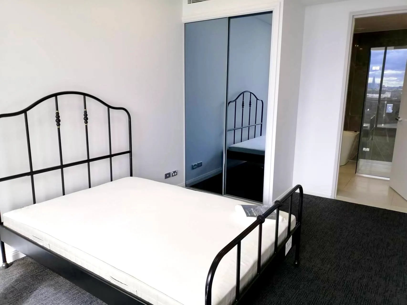 Bed wardrobe and bathroom visible bedroom at Belong Mascot in Sydney Student Accommodation