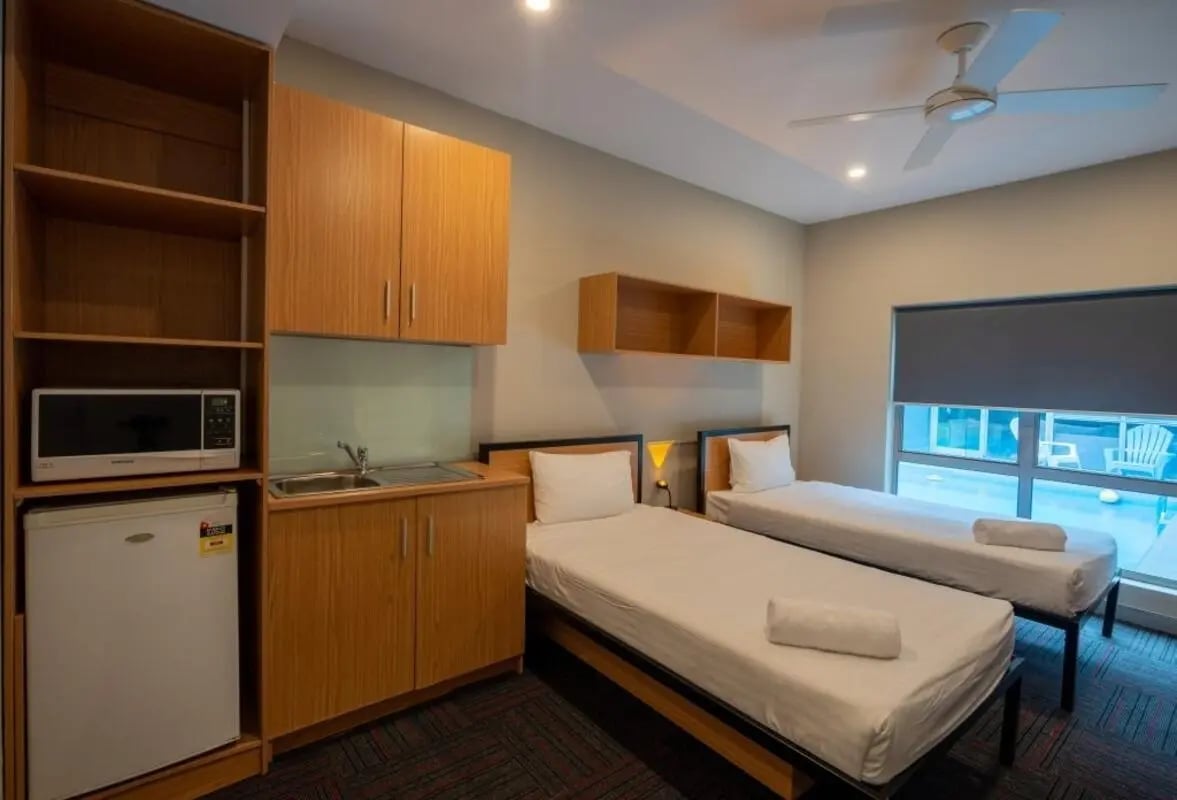 Two beds microwave sink cabinets and shelves bedroom at Sydney Student Living Concord in Sydney Student Accommodation