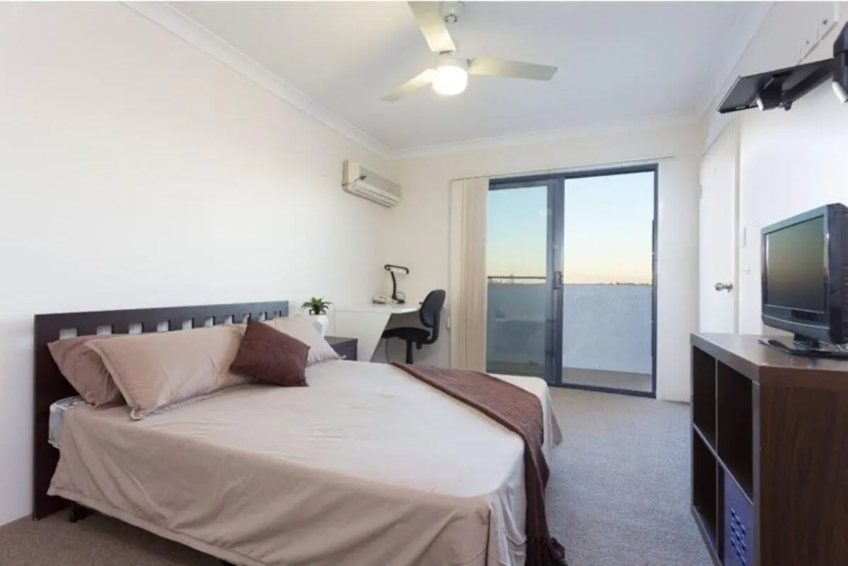 Bed desk ceiling fan sliding door television bedroom at Altitude Taringa in Brisbane Student Accommodation