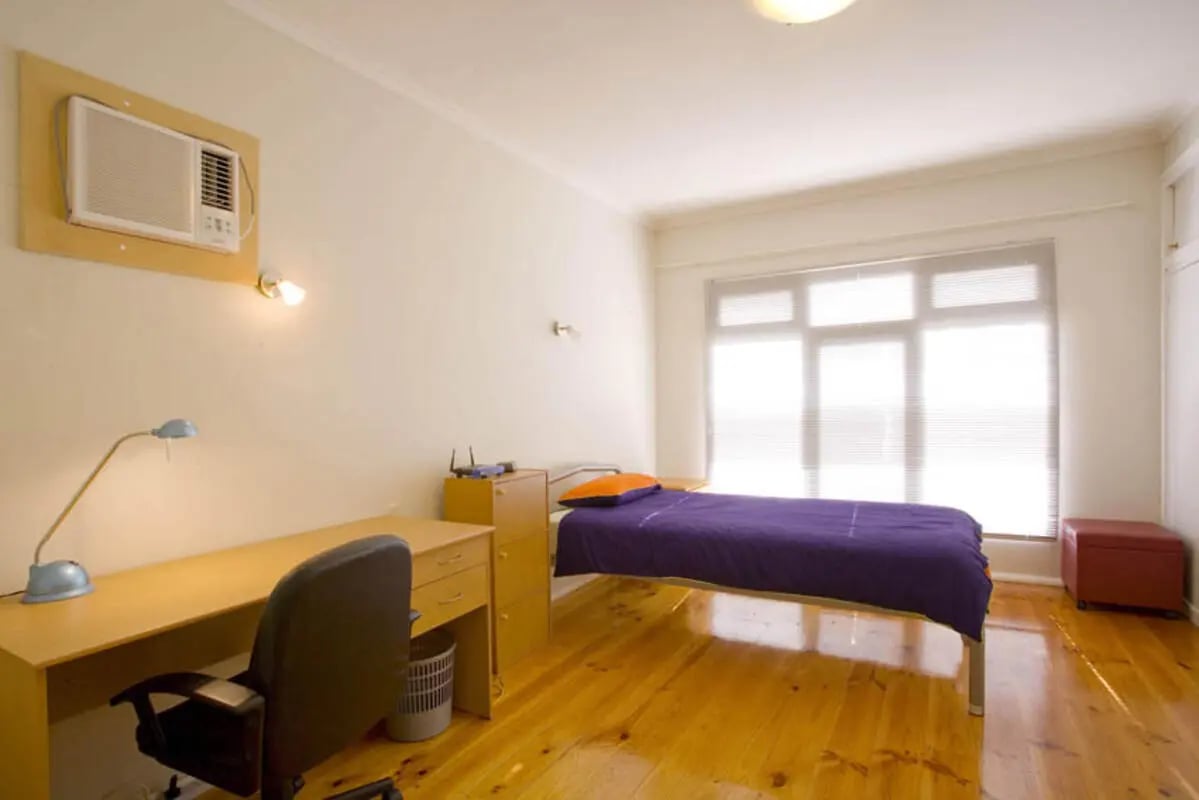 Bed desk lamp air conditioner and chair bedroom at Classical House in Melbourne Student Accommodation