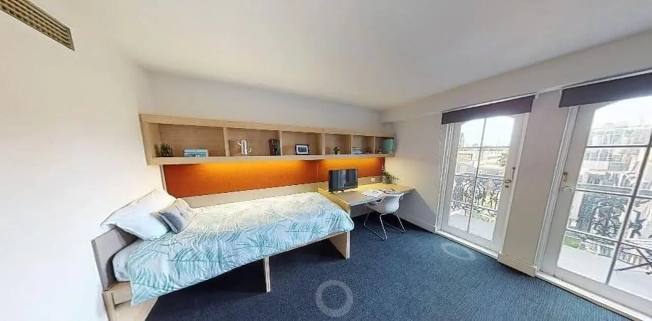 Bed desk and shelves bedroom exterior at dwell Village Melbourne City in Melbourne Student Accommodation