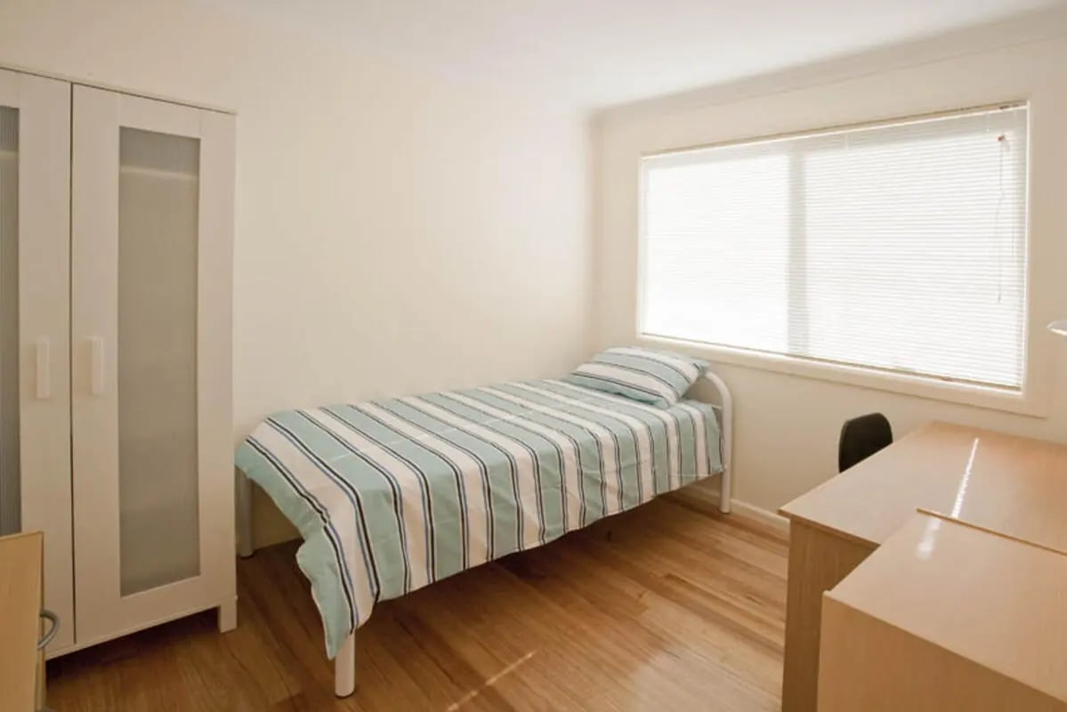 White wardrobe single bed blinds desk bedroom at Sunset House in Melbourne Student Accommodation