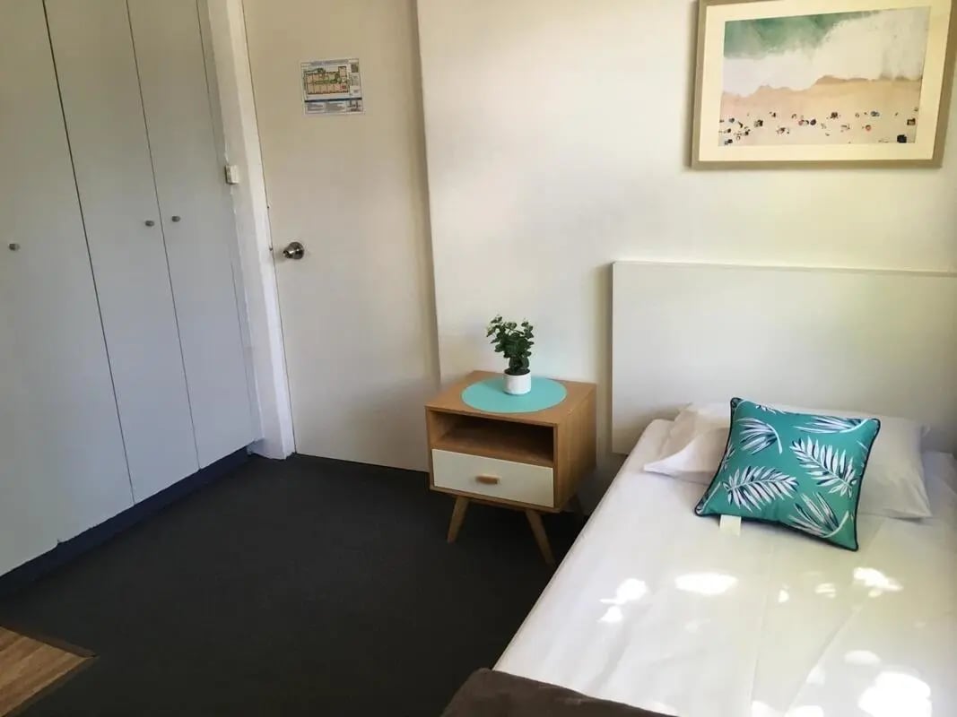 Bed nightstand plant artwork and closet bedroom at ume Hyde Park in Sydney Student Accommodation