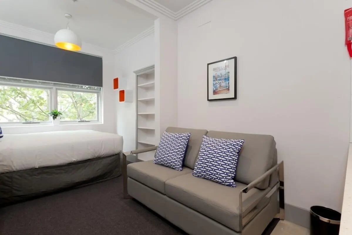 Bed couch shelves framed picture living room at ume Darlinghurst in Sydney Student Accommodation