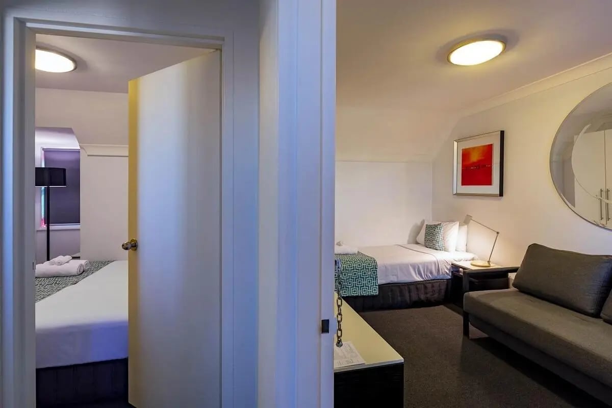 Two beds couch and artwork living room at ume Redfern Village in Sydney Student Accommodation