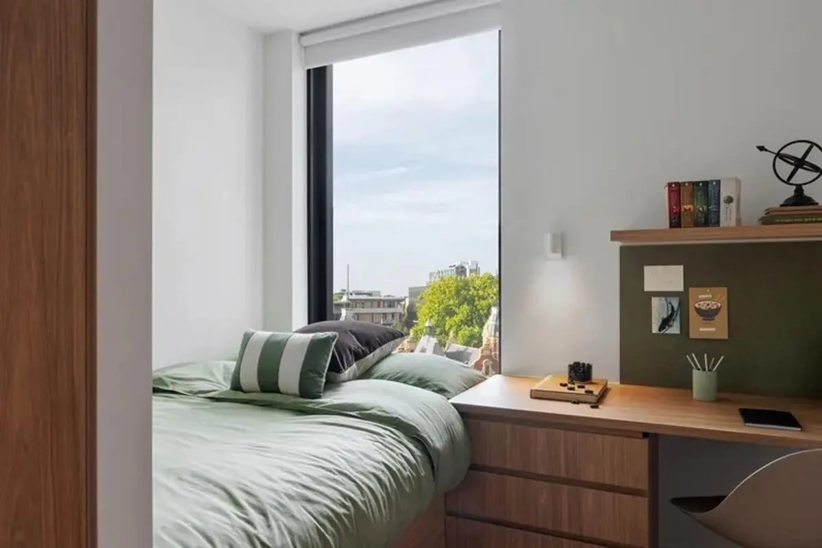 Bed desk books and window Bedroom at Campus House in Melbourne Student Accommodation