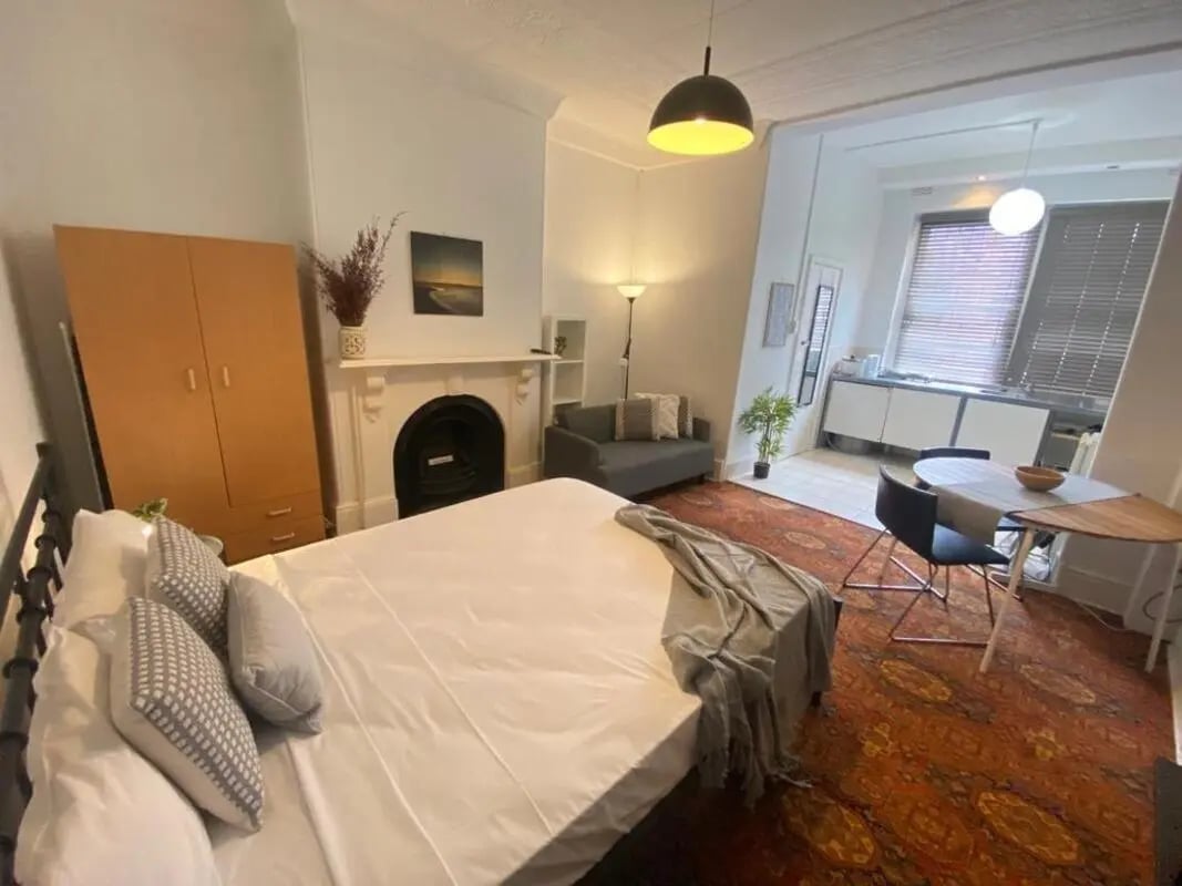 Bed wardrobe fireplace sofa kitchen dining area studio at ume 150 Darlinghurst Village in Sydney Student Accommodation