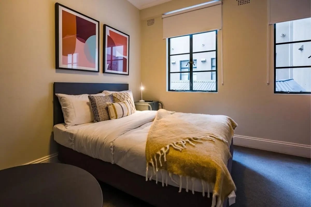 Bed with pillows artwork and window bedroom at ume Haymarket in Sydney Student Accommodation