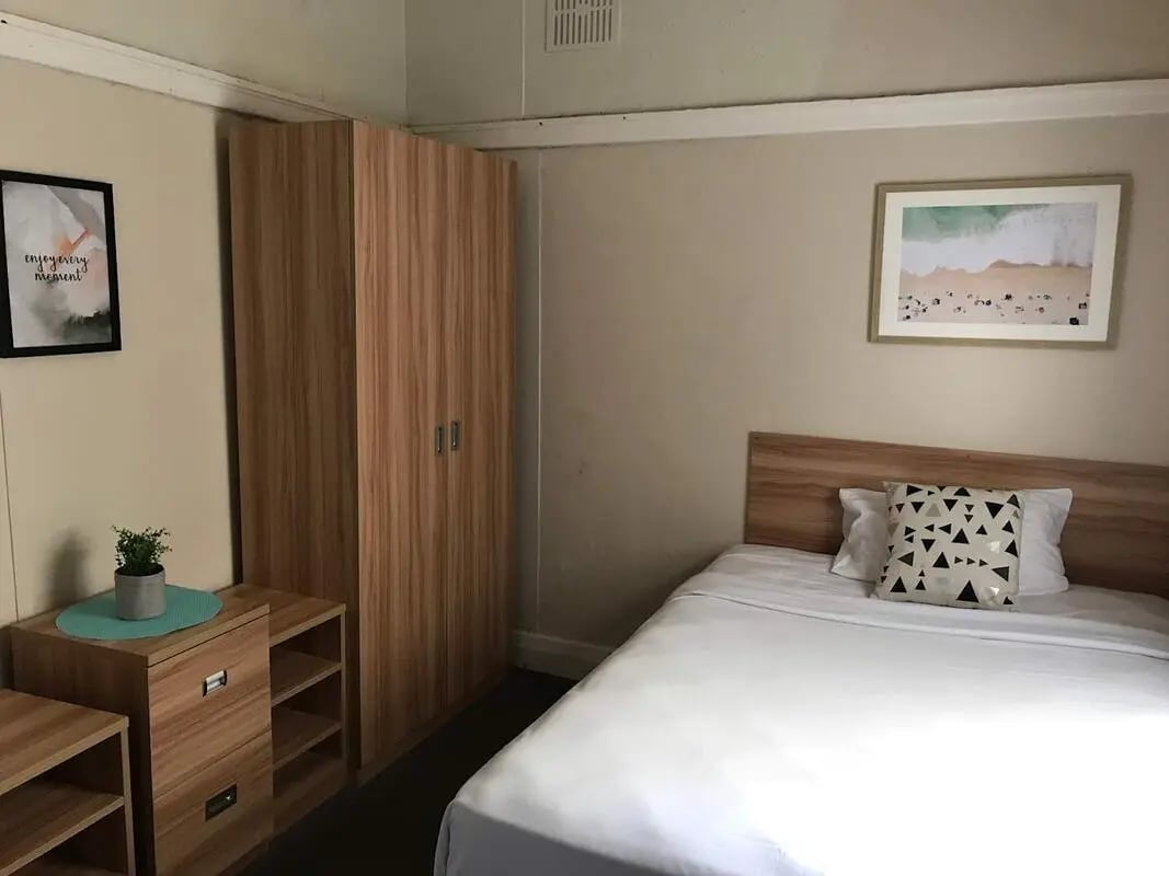 Wardrobe and bed with framed art Bedroom at ume Potts Point in Sydney Student Accommodation