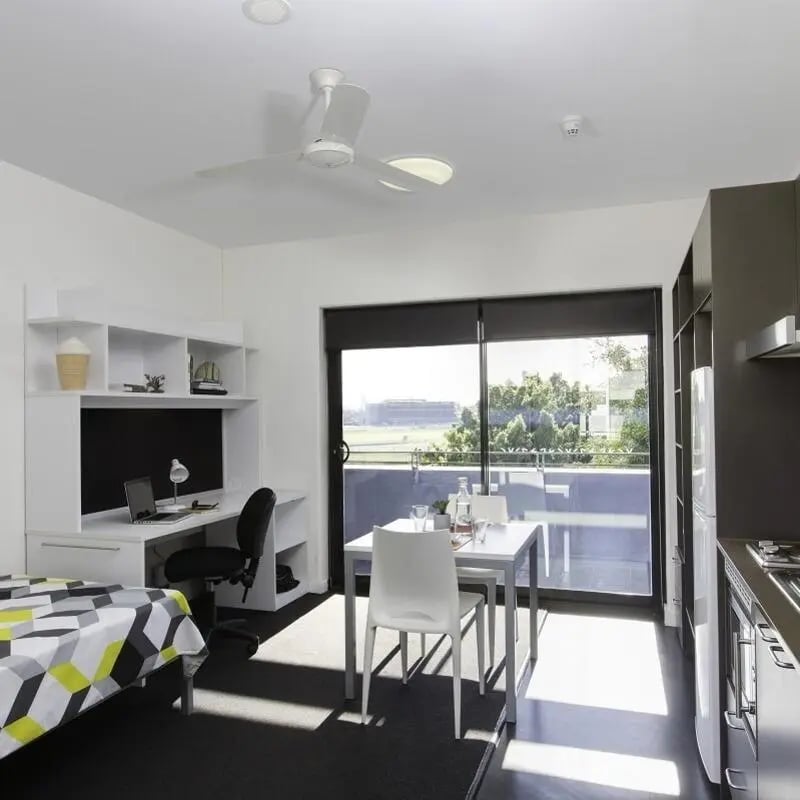 Bed desk dining table with chairs living room at UNSW Village in Sydney Student Accommodation
