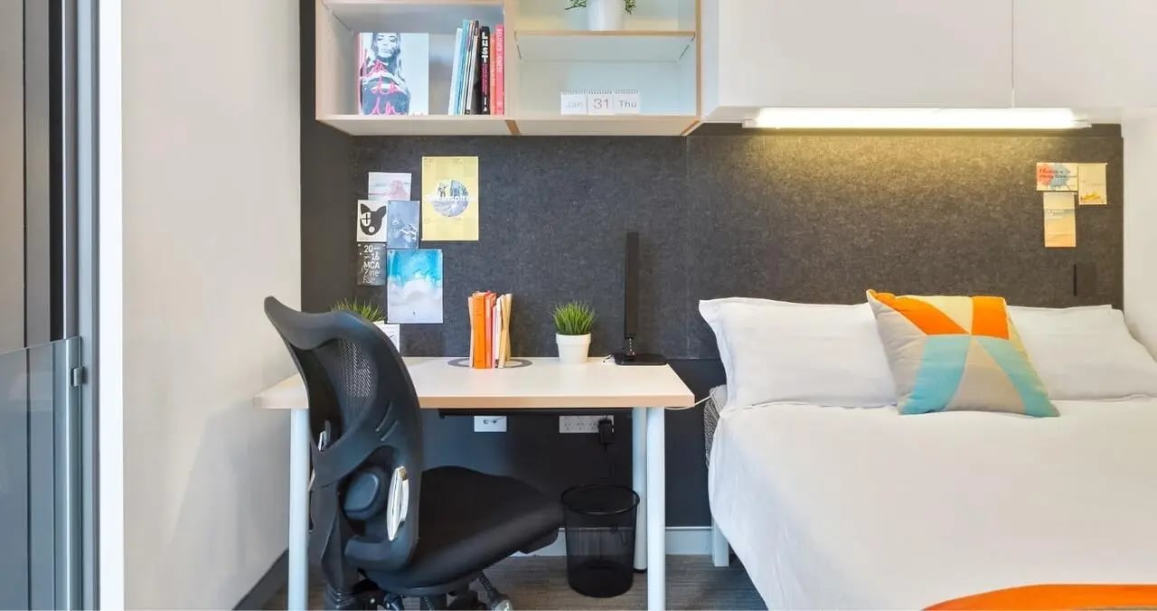 Desk chair bed and pillows bedroom at Iglu Central in Sydney Student Accommodation