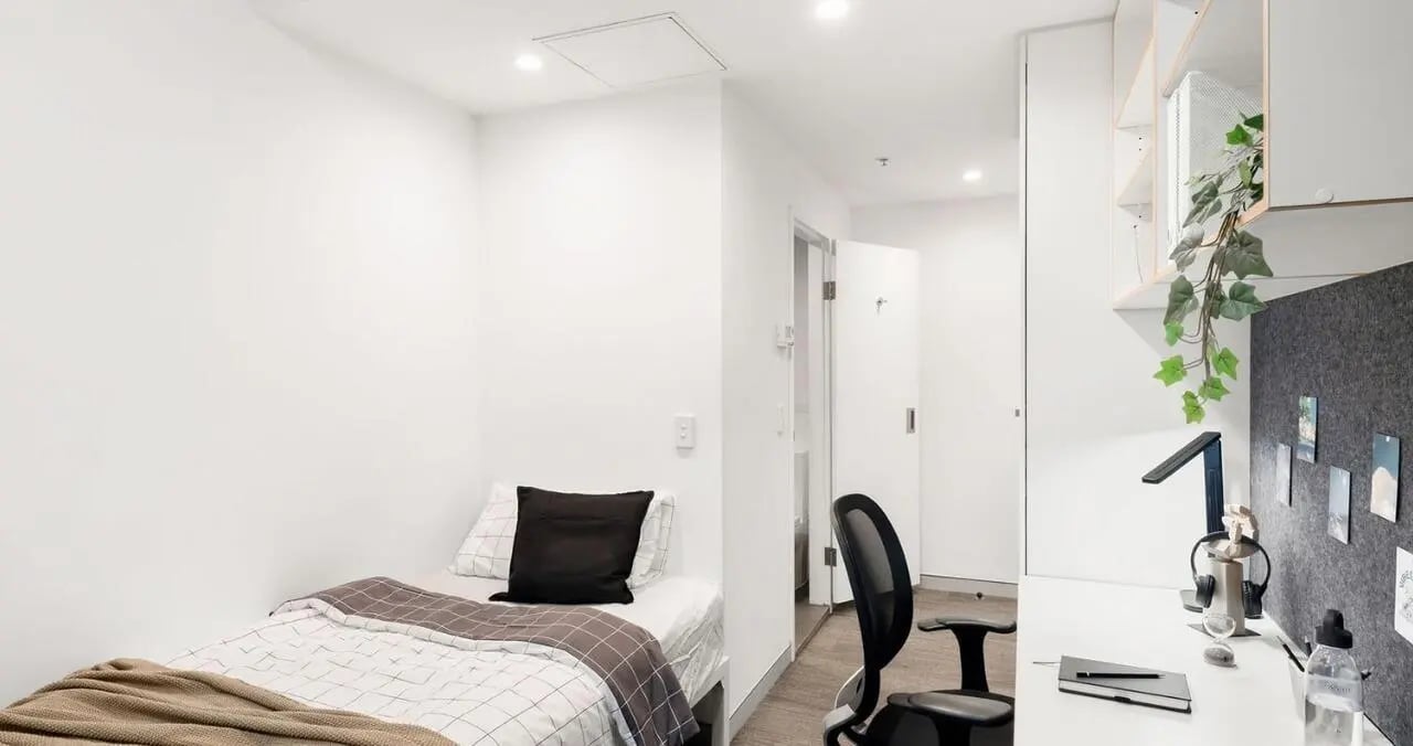 Bed desk chair plant storage and door bedroom at Iglu Central in Sydney Student Accommodation