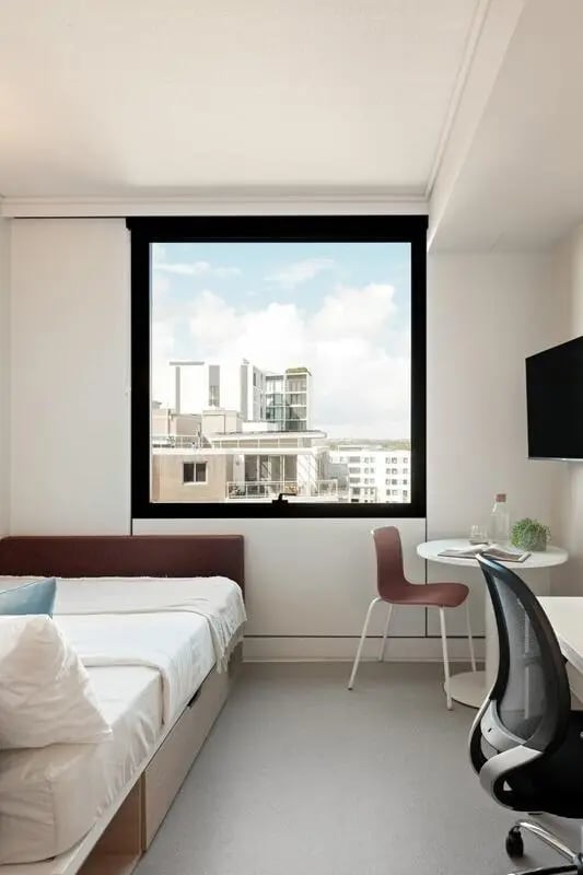 Bed white linens desk chair study area bedroom at Iglu Mascot in Sydney Student Accommodation
