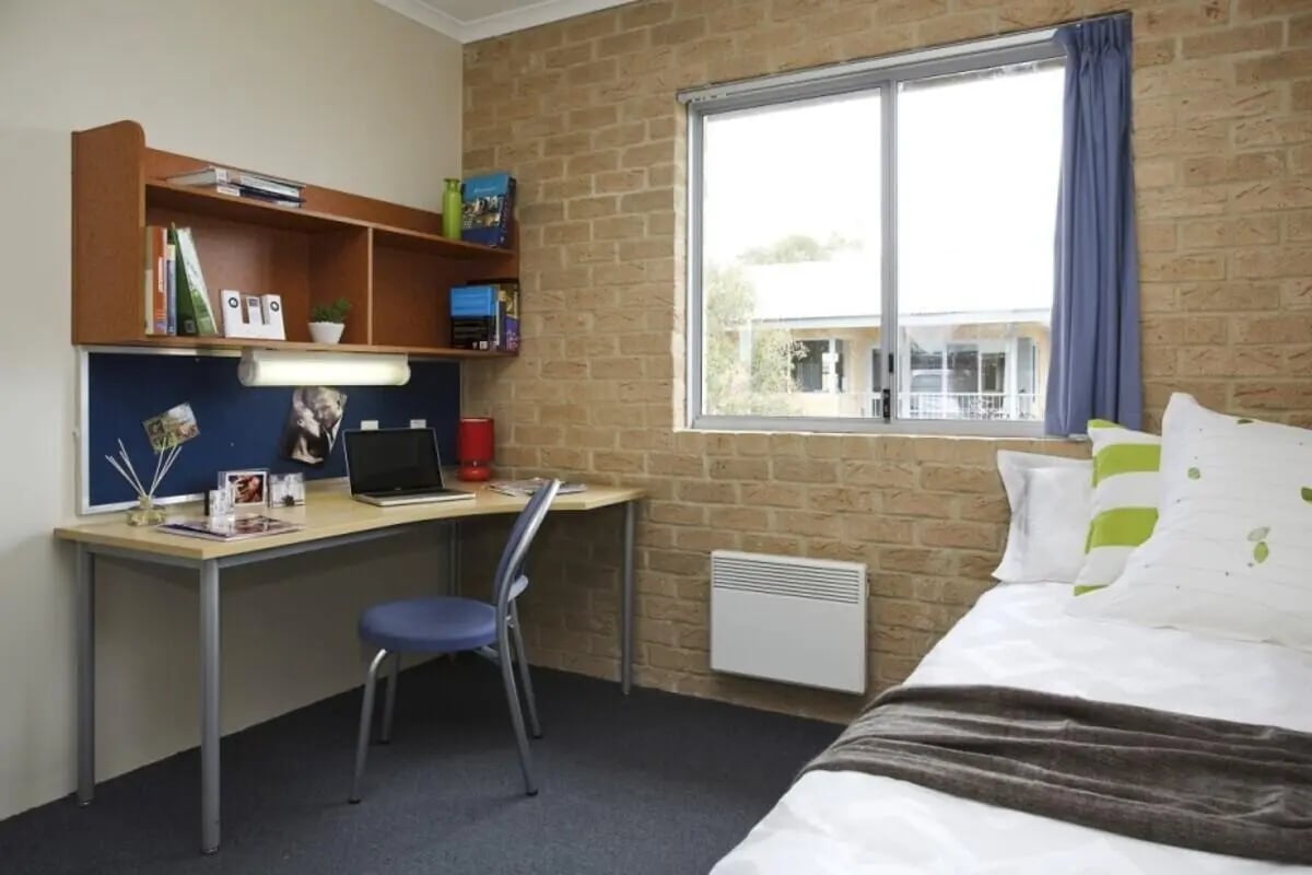 Desk chair laptop shelf books and bed Bedroom at ECU Village Bunbury in Bunbury Student Accommodation