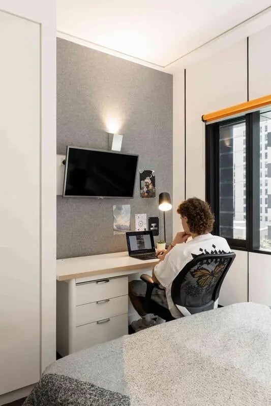 Student at desk with laptop and television study area at Iglu Brisbane City in Brisbane Student Accommodation