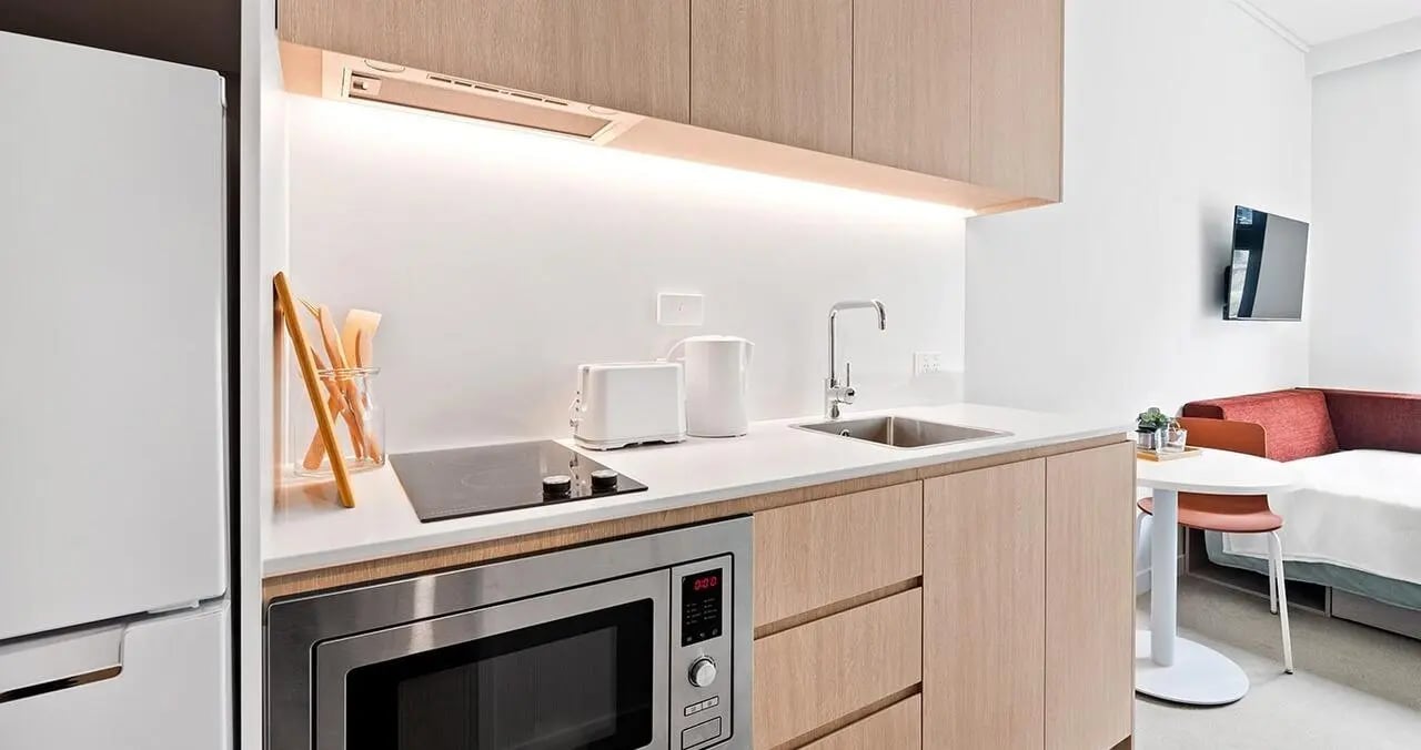 Fridge microwave toaster kettle sink and couch kitchen at Iglu Flagstaff Gardens in Melbourne Student Accommodation