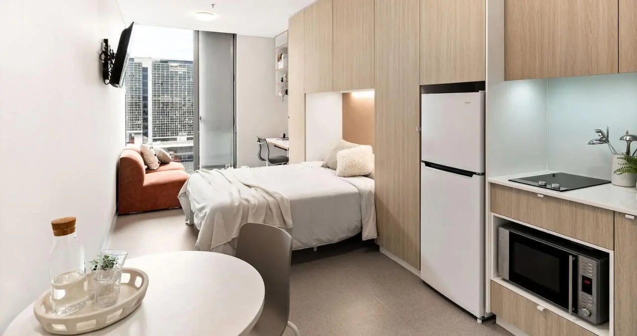Bed sofa desk kitchenette refrigerator and microwave studio apartment at Iglu Central Park in Sydney Student Accommodation