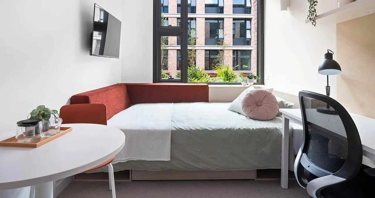 Bed desk chair and TV bedroom at Iglu Summer Hill in Sydney Student Accommodation