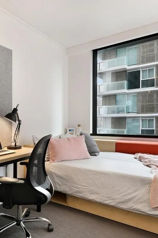 Desk chair bed with pillows and window Bedroom at Iglu South Yarra in Melbourne Student Accommodation