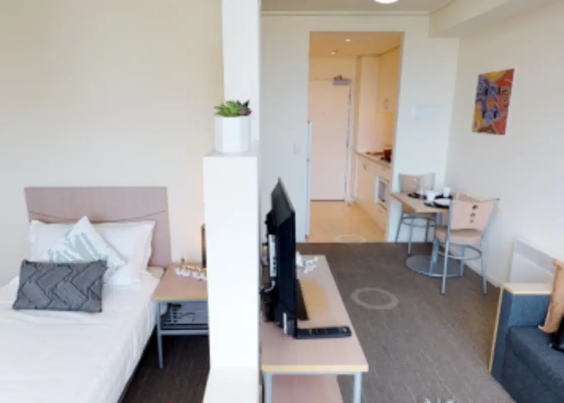 Bed TV dining area and kitchen studio apartment at Student Living - 800 Swanston in Melbourne Student Accommodation