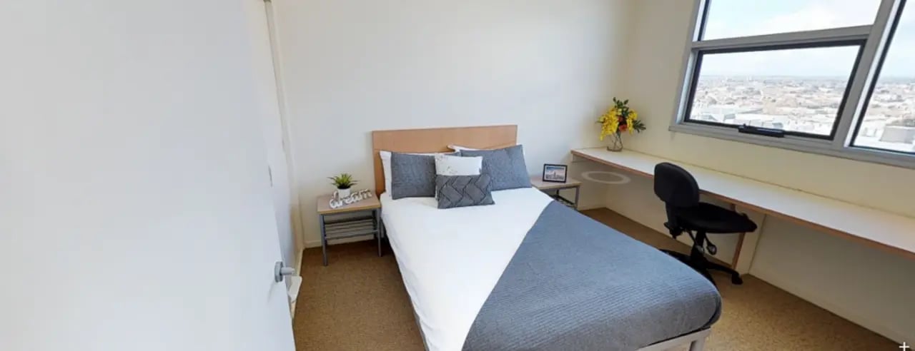 Bed desk chair and window bedroom at Student Living - 800 Swanston in Melbourne Student Accommodation