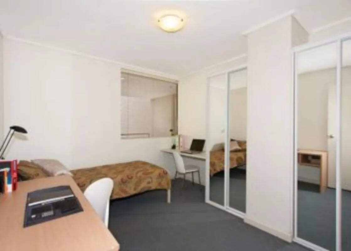 Desk bed and mirrored wardrobe bedroom at Student Living On ABeckett in Melbourne Student Accommodation