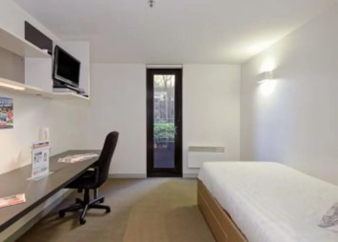 Bed desk tv door and chair bedroom at Student Living on Riversdale in Melbourne Student Accommodation