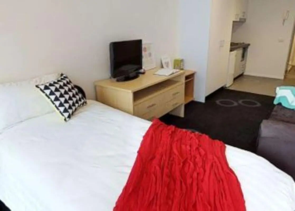 Bed television dresser and kitchen studio apartment at Student Living - 740 Swanston in Melbourne Student Accommodation