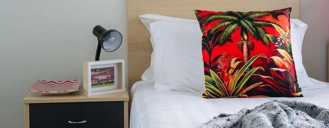 Bedside table lamp framed picture pillow bedroom at Student Living on Lonsdale in Melbourne Student Accommodation