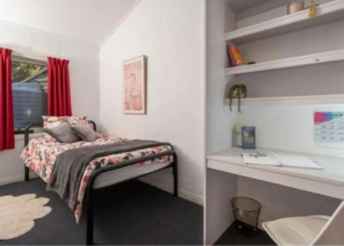 Bed with floral duvet and desk with shelves bedroom at UniLodge Wodonga East End in Wodonga Student Accommodation