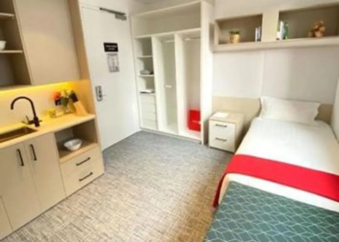 Small kitchen sink and bed with red throw. Bedroom. at UniLodge Ultimo in Sydney Student Accommodation