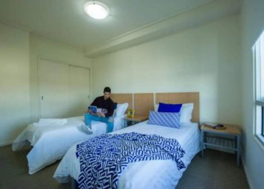 Two beds with blue blankets and pillows Bedroom at Student Living - 570 Lygon in Melbourne Student Accommodation
