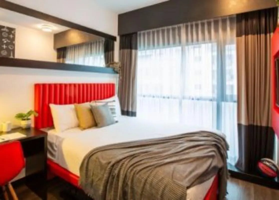 Red bed desk chair and window bedroom at UniLodge Carlton in Melbourne Student Accommodation