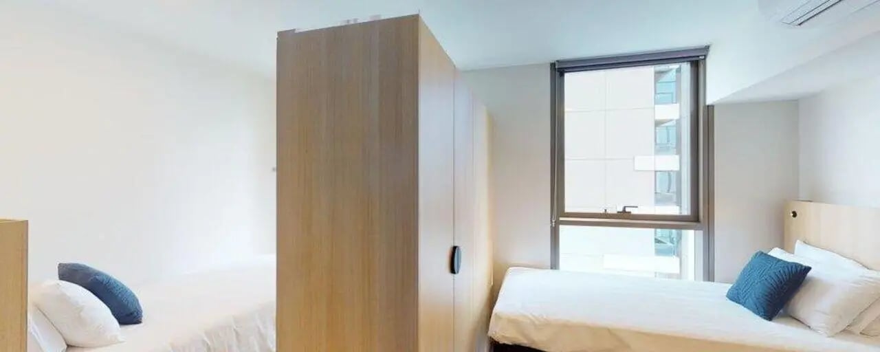 Two beds wardrobe and window bedroom at Unilodge Melbourne City in Melbourne Student Accommodation