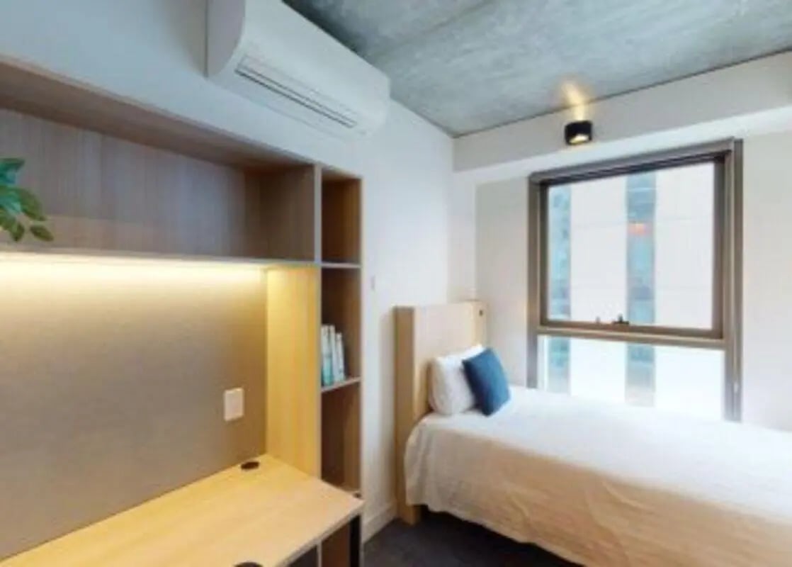 Bed desk bookshelf air conditioner bedroom at Unilodge Melbourne City in Melbourne Student Accommodation