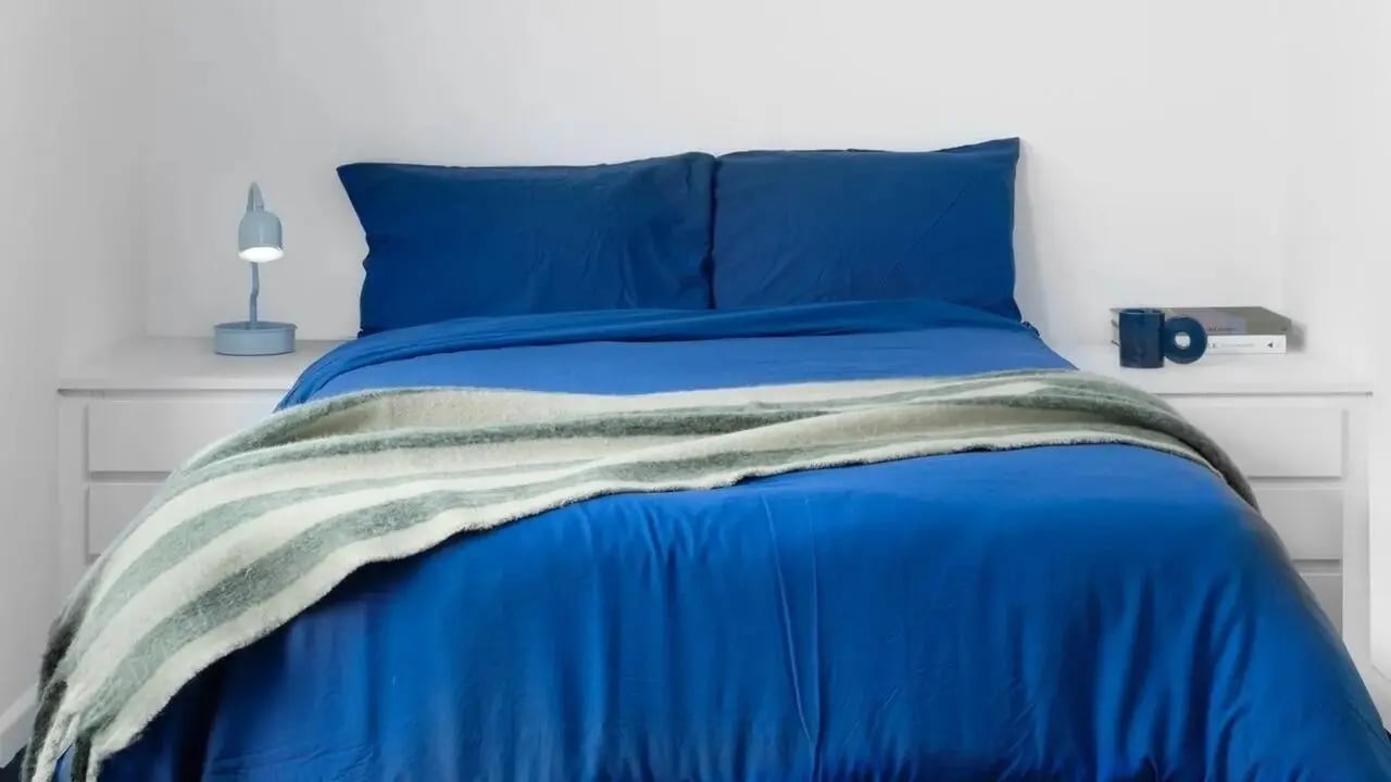 Blue duvet with striped blanket on bed bedroom at Scape Mile End in London Student Accommodation