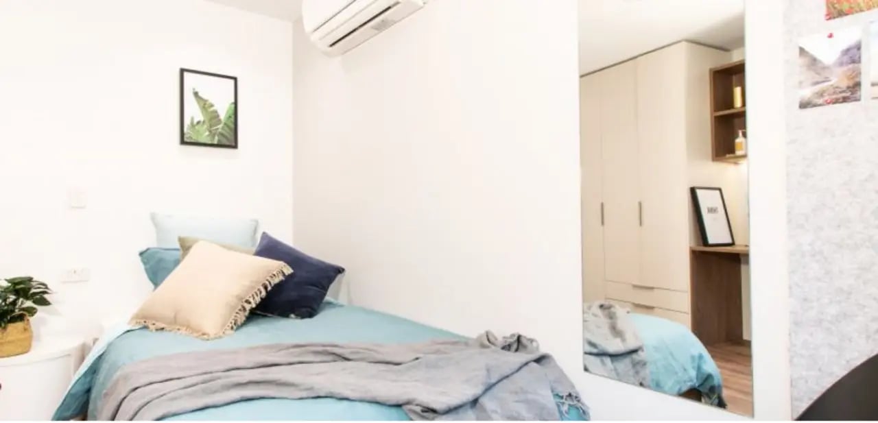 Bed with pillows blanket air conditioner bedroom at UniLodge Park Avenue in Melbourne Student Accommodation