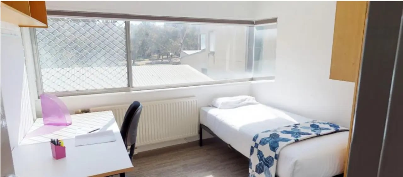 Bed desk chair window and radiator bedroom at UniLodge @ UC - Campus West & Guginya in Canberra Student Accommodation