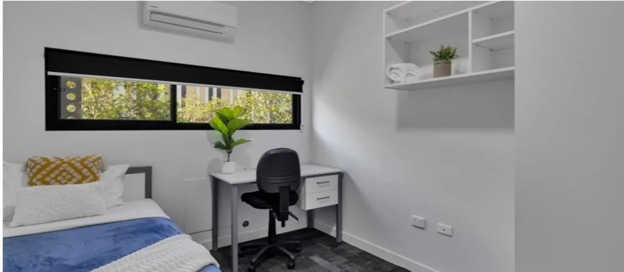 Bed desk chair shelves and plant bedroom at Western Sydney University Penrith Village in Sydney Student Accommodation