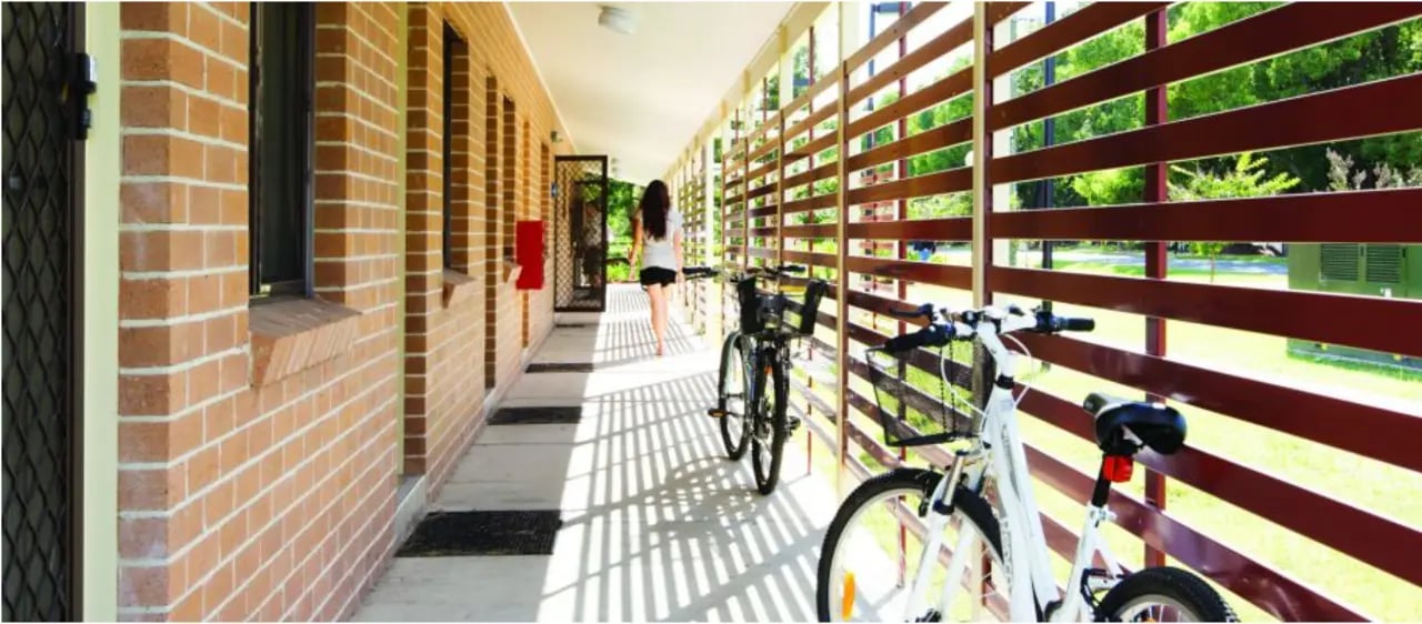 Corridor with bikes and person exterior at Western Sydney University Hawkesbury Village in Sydney Student Accommodation